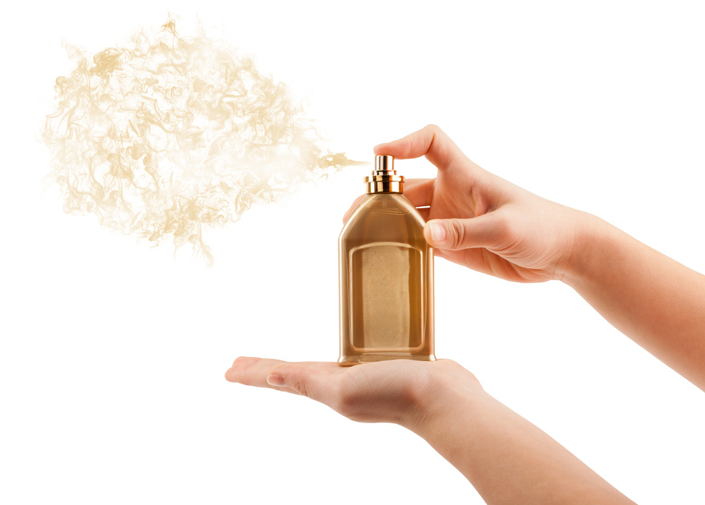 close up of woman hands spraying perfume